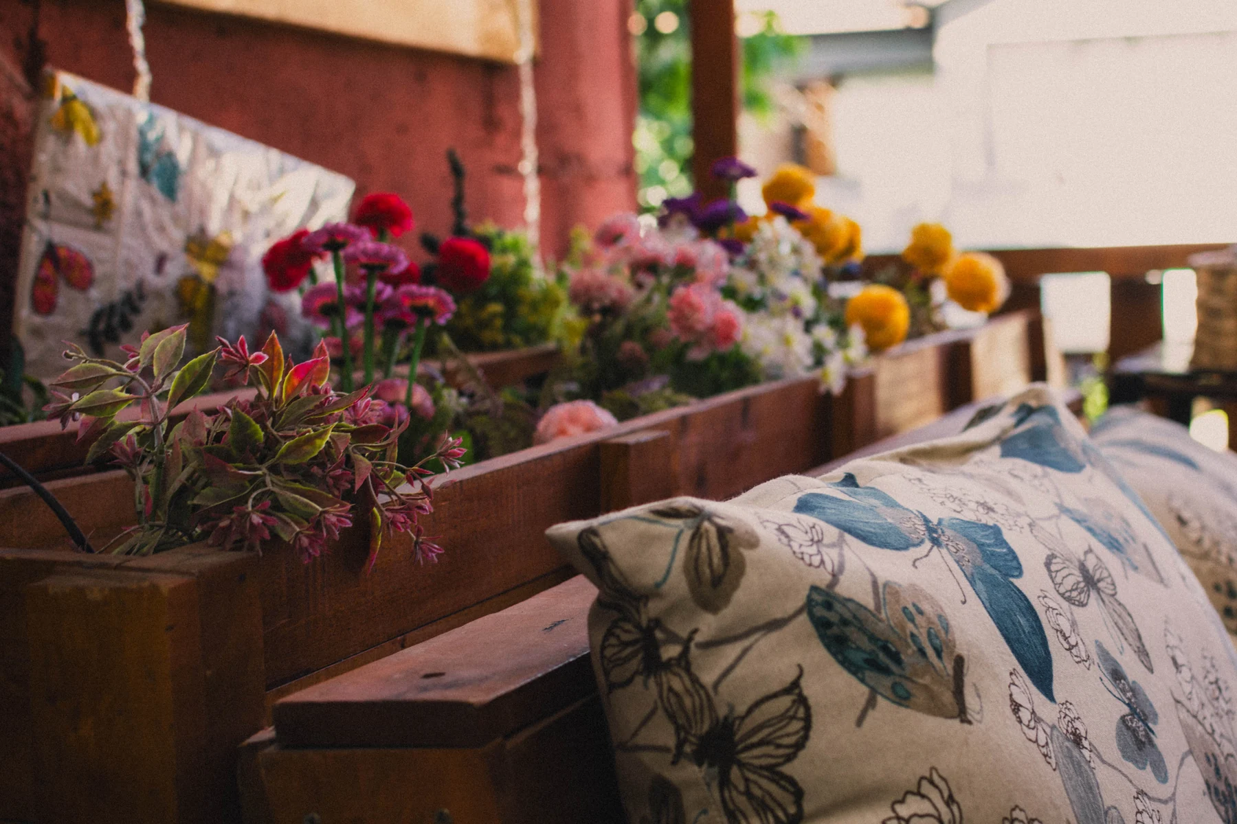 Detalle de terraza con jardinera de flores y cojín decorativo